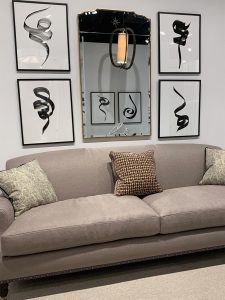 Art work by Elyse Defoor mounted on black frames on a white wall in a living room setting