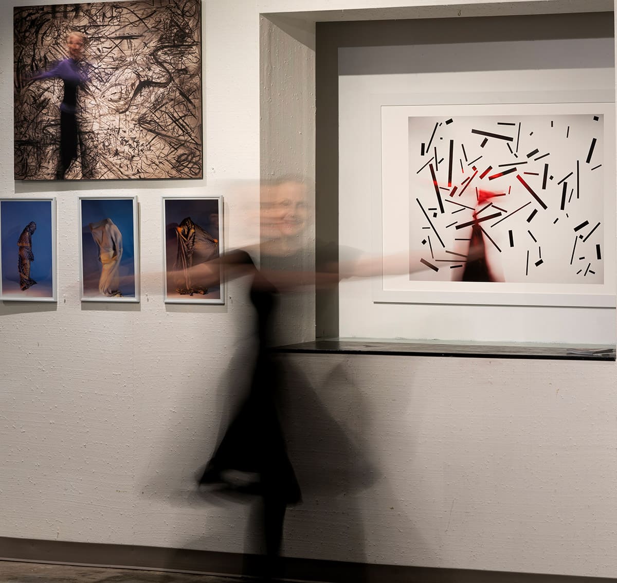 Elyse Defoor in front of her paintings in an exhibition space.